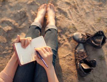 woman journaling on the beach
